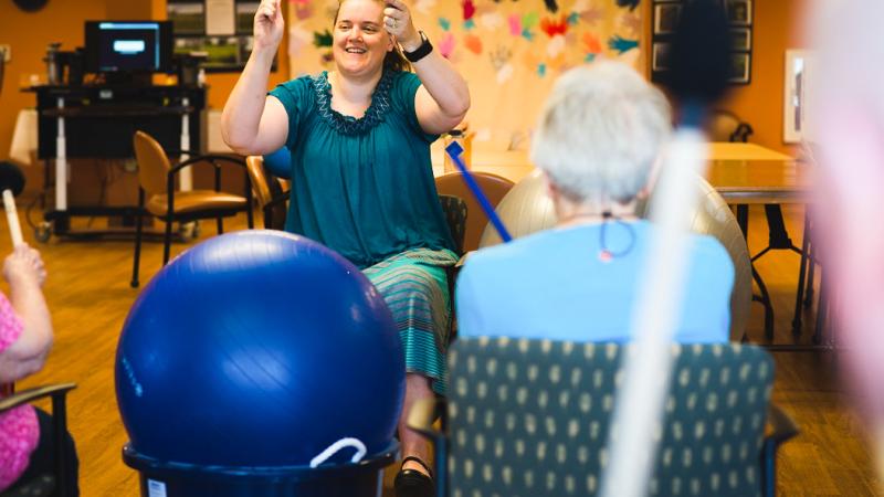 Melissa Cole, center, music therapist at Oakwood Village in Madison, Wisconsin, sings with residents.