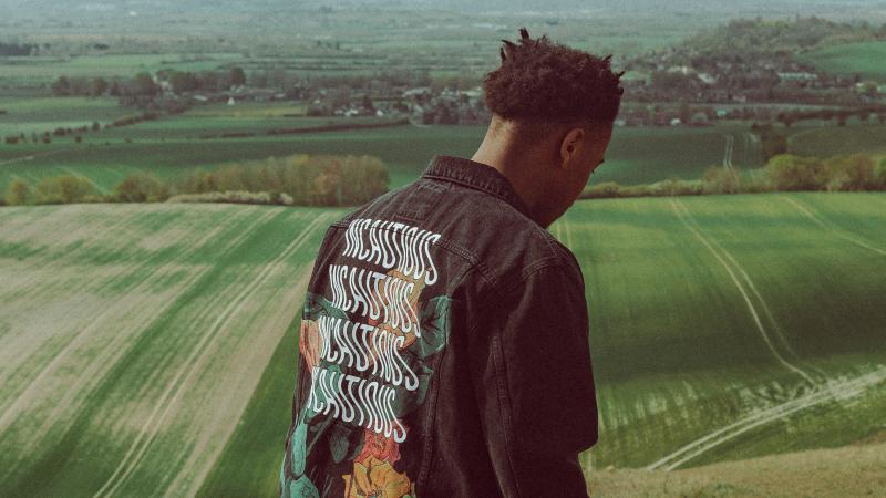 a black man looks at a field